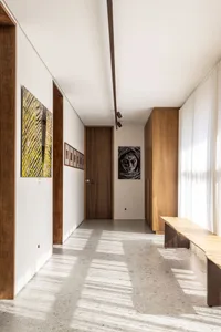 Modern minimalist corridor with wooden doors, concrete floor, and smooth finish