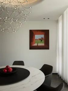 Modern dining room featuring a white marble table with black marble accents and a black chandelier hanging from the ceiling.