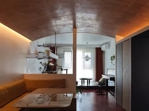 Modern living room featuring concrete walls and glass doors.