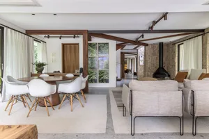A modern living room featuring wooden furniture, stone walls, and fabric seating.