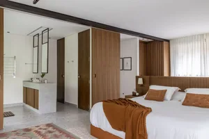 A modern minimalist bedroom featuring wooden accents and a cozy atmosphere