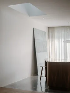 A minimalist kitchen featuring modern design elements with marble and concrete finishes.