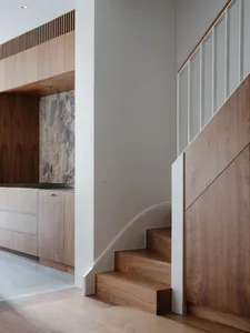 A modern staircase featuring wooden paneling and a minimalist design.