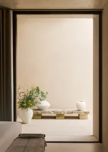 簡約空間內有混凝土牆面、花瓶，以及石凳上的一盆仙人掌植物。
