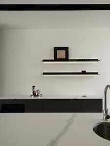 Modern minimalist kitchen with white marble countertops and black shelving.