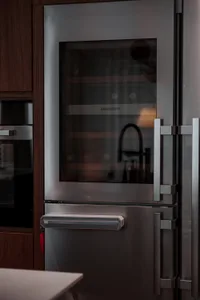Close-up view of a modern industrial kitchen with a stainless steel wine cooler.