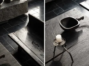 An antique wooden furniture piece with a candle and a wooden bowl on a vintage table.