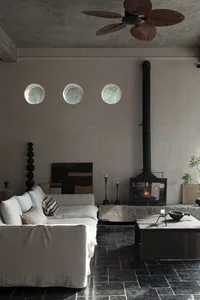 A cozy industrial living room with a concrete fireplace, wooden coffee table, and minimalist decor.