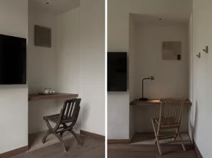 A minimalist home office with a wooden desk, chair, and wall-mounted television.