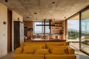 A modern living room with wooden furniture, glass windows, and metal fixtures.