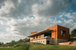 Modern house with stone and concrete exterior, featuring contemporary design and open spaces.