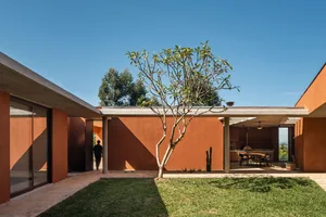 Outdoor view of a modern residential exterior featuring a concrete slab roof and walls.