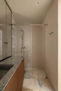 Interior design of a minimalist bathroom featuring marble and glass elements.