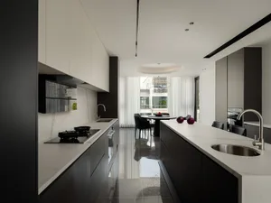 A modern minimalist kitchen with black and white color scheme and marble countertops.