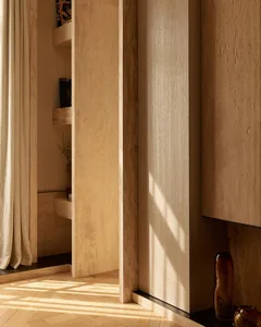 A minimalist interior design featuring wooden elements and a natural light source.