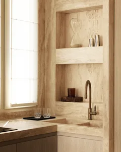 A minimalist kitchen featuring a marble countertop and sink with a decorative hourglass on a shelf.