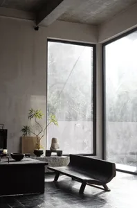 Minimalist living room with concrete elements and large windows.