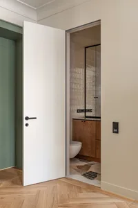 A modern bathroom featuring wooden flooring, glass doors, and ceramic tiles on the walls.