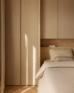 A minimalist bedroom with a wooden bed, neutral colors, and a sleek, modern design.