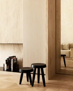 Modern minimalist interior featuring wooden stools and books.