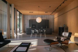 A modern living room featuring black metal kitchen cabinets and wood-textured walls and ceiling.