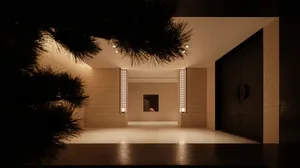 Modern minimalist interior space with concrete walls and floor, minimalist furniture, and a central fireplace.