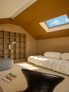 Modern living room with minimalistic design, neutral color palette, and a skylight.