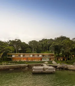 A modern residential building with glass walls and wooden elements.