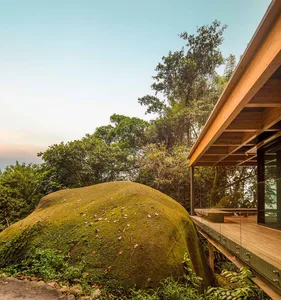 Modern residential exterior featuring wooden structures and glass elements.