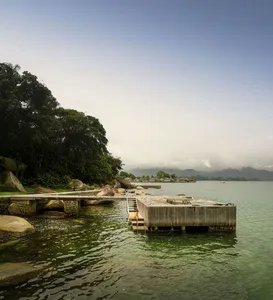 A waterfront resort with a wooden pier and stone pavilion.