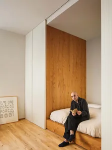 A minimalist bedroom featuring a wooden platform bed and a wooden headboard.