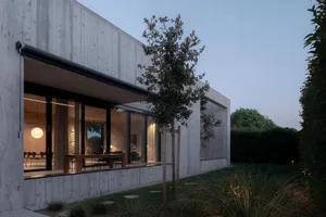 A modern residence with concrete walls and glass windows.
