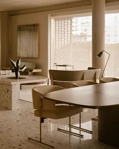 Modern dining room featuring a round table with terrazzo and concrete materials.