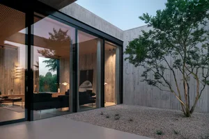 Modern residential interior with concrete walls and glass sliding doors.