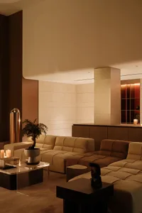 A modern living room with leather sofas, concrete walls, and wooden accents.