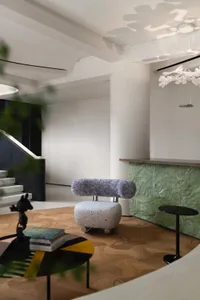 A modern living room featuring a terrazzo and marble interior design with a unique chair and table setup.