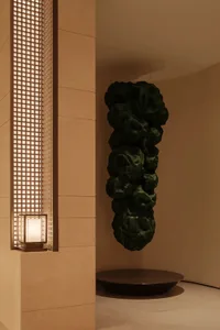 A modern lobby featuring a metallic sculpture hanging from the ceiling.