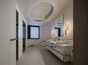 Modern bathroom with marble accents, white marble countertops, and a sink with a floating vanity.