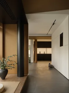 A modern minimalist interior with concrete flooring and black columns.