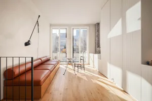 Modern minimalist living room with wood flooring, steel accents, and natural light.