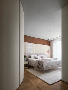 Modern bedroom featuring white furniture, wood floors, and a minimalist design.