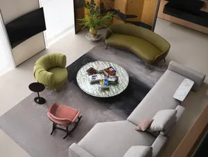 Modern living room with textured furniture, round glass coffee table, and curved sofas, featuring a vase of flowers and books