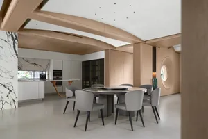 Contemporary kitchen and dining room featuring marble countertops and wooden elements.