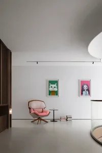 A minimalist modern living room with a concrete floor, wooden furniture, and a glass table.