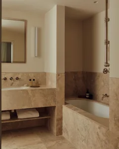 Modern minimalist bathroom featuring marble tiles and fixtures.