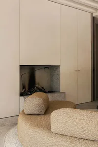 Modern minimalist living room featuring fabric seating and concrete fireplace