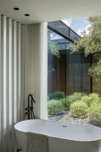 Modern bathroom with a glass window and view of outdoor greenery.