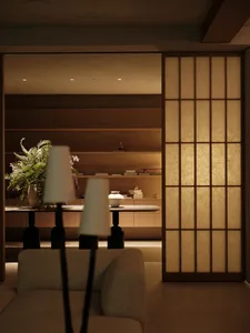 A modern interior design featuring wooden paneling and paper lampshades, with a cozy living room atmosphere.