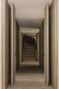 A modern interior space with a wooden staircase and walls.