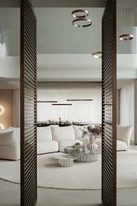 Modern living room with a glass coffee table, marble accents, and neutral-colored furniture.